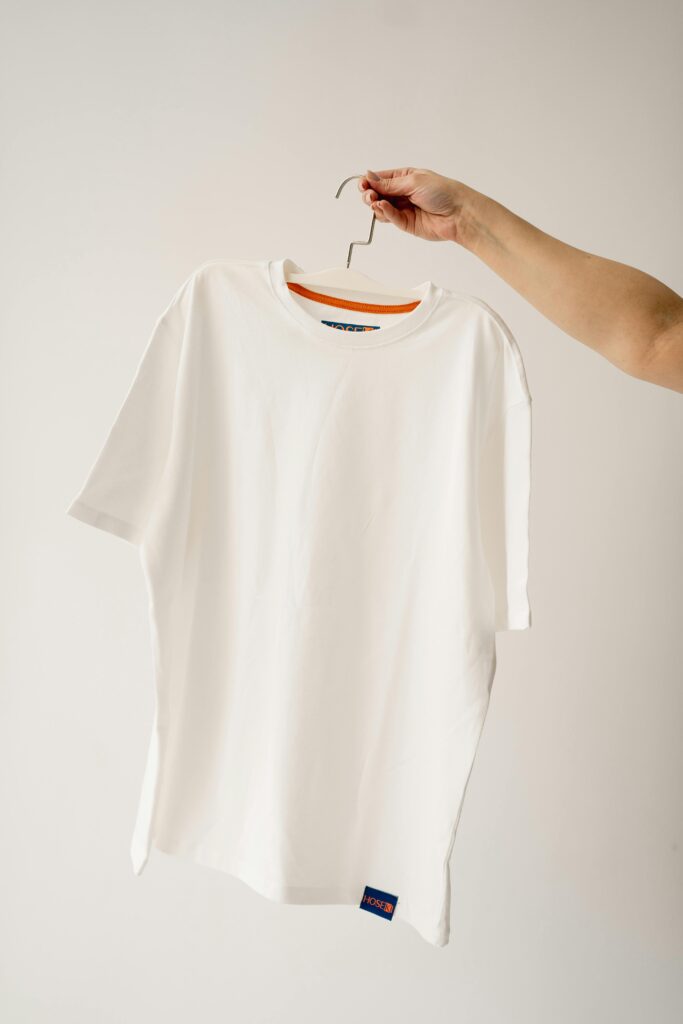 pexels-photo-20669538-20669538 Hand Holds Hanger with T-shirt